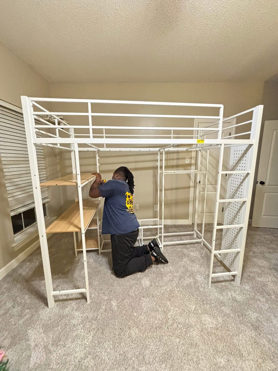 Reuben assembling a loft bed with built-in desk